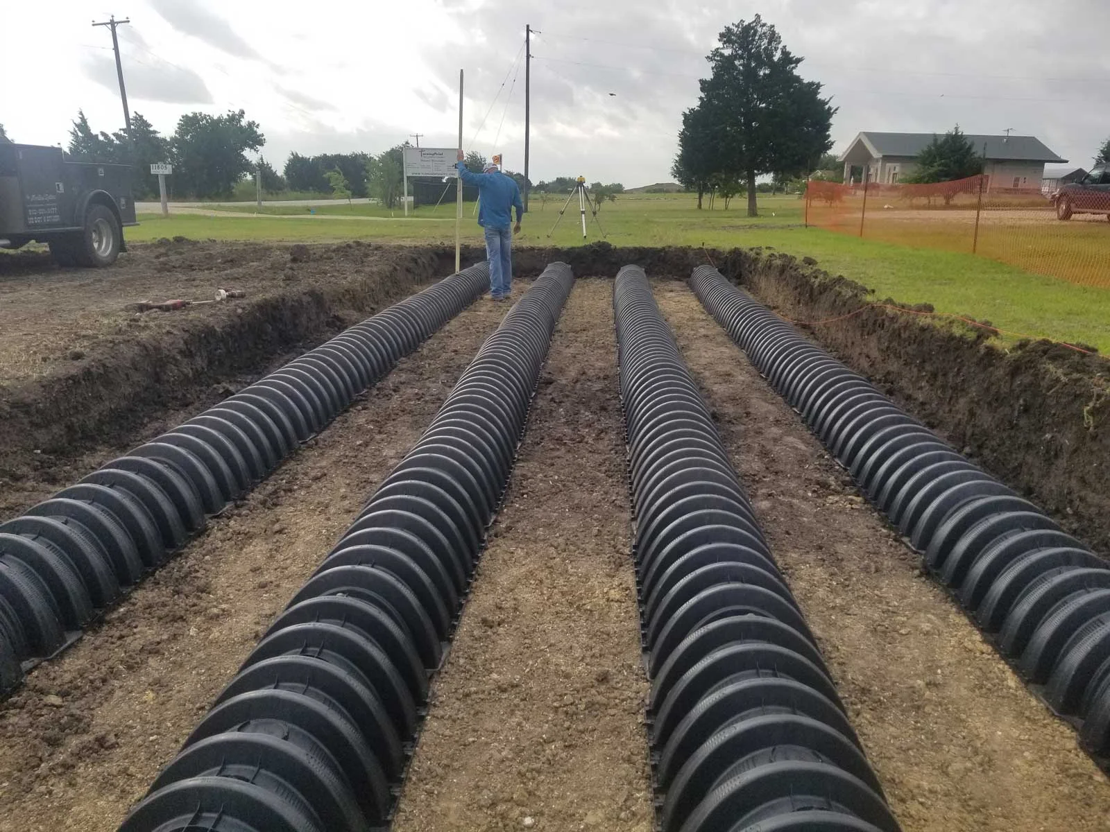 “Commercial septic tanks being installed in a prepared trench with heavy equipment in Central Texas.”